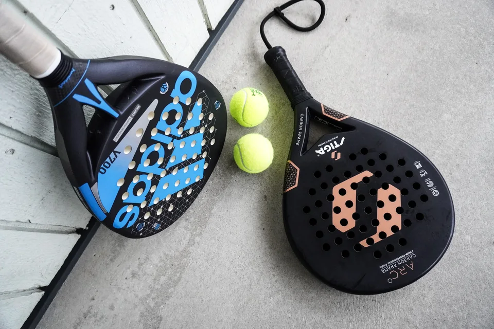 Padel rackets and balls on a bench