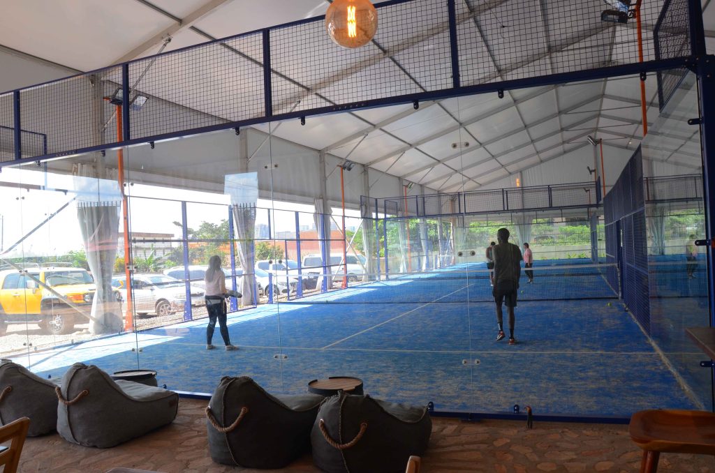 Four players playing padel on a blue indoor court at Nsambya, Uganda